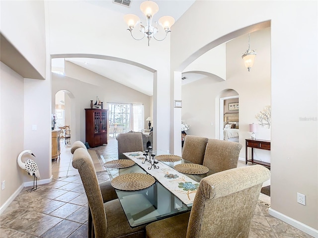 dining room with lofted ceiling, tile floors, and a notable chandelier