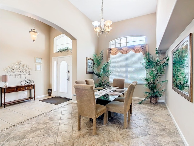 tiled dining space featuring a chandelier and a high ceiling