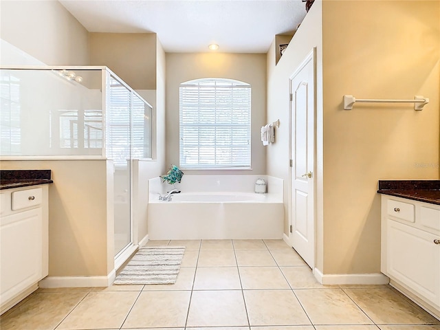 bathroom featuring tile flooring, vanity, and plus walk in shower