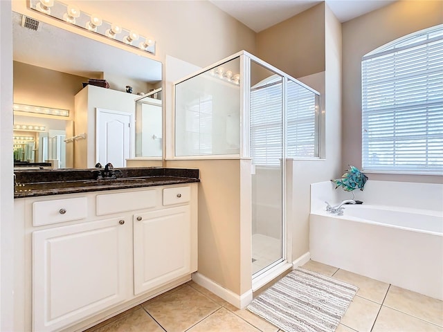 bathroom featuring vanity, shower with separate bathtub, tile floors, and a wealth of natural light