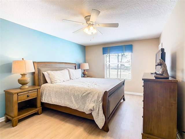 bedroom with a textured ceiling, ceiling fan, and hardwood / wood-style flooring