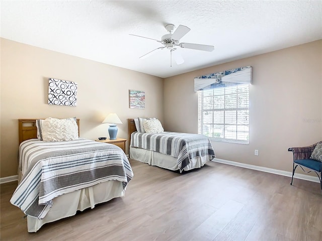 bedroom featuring hardwood / wood-style flooring, ceiling fan, and a textured ceiling