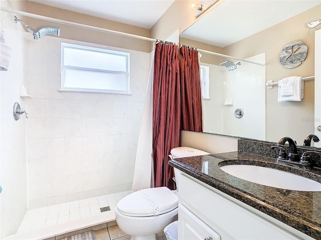 bathroom with tile floors, toilet, large vanity, and a shower with shower curtain