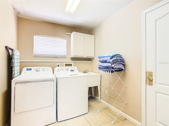 laundry area with light tile flooring, washer and dryer, cabinets, and sink