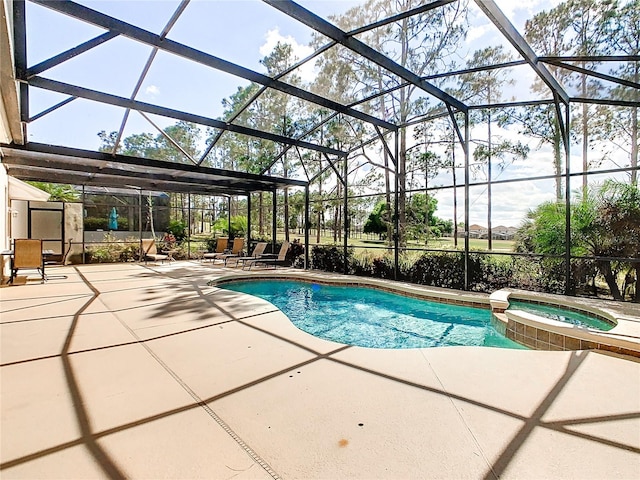 view of pool featuring a patio area, an in ground hot tub, and glass enclosure