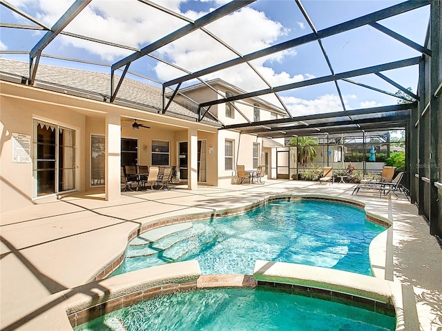 view of pool with glass enclosure, an in ground hot tub, ceiling fan, and a patio area