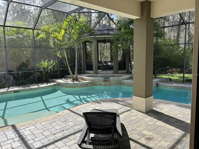 view of swimming pool with a patio, a lanai, and an in ground hot tub