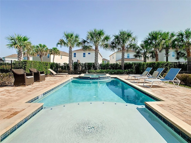 view of swimming pool featuring a patio and an in ground hot tub