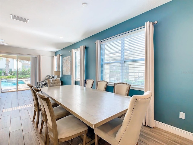 dining area with a wealth of natural light and light hardwood / wood-style flooring