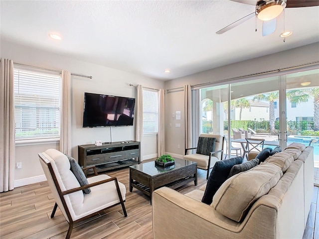 living room featuring ceiling fan and light hardwood / wood-style flooring