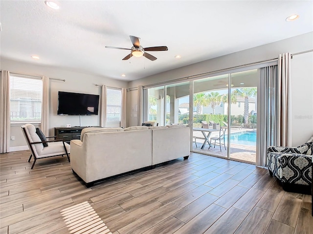 living room featuring a wealth of natural light, light hardwood / wood-style flooring, and ceiling fan