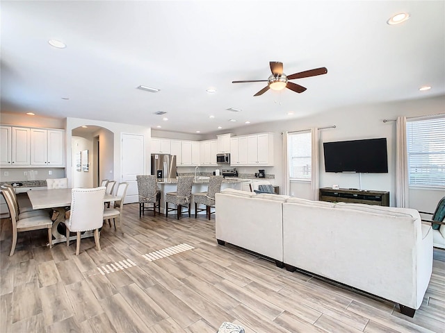 living room featuring light hardwood / wood-style flooring and ceiling fan