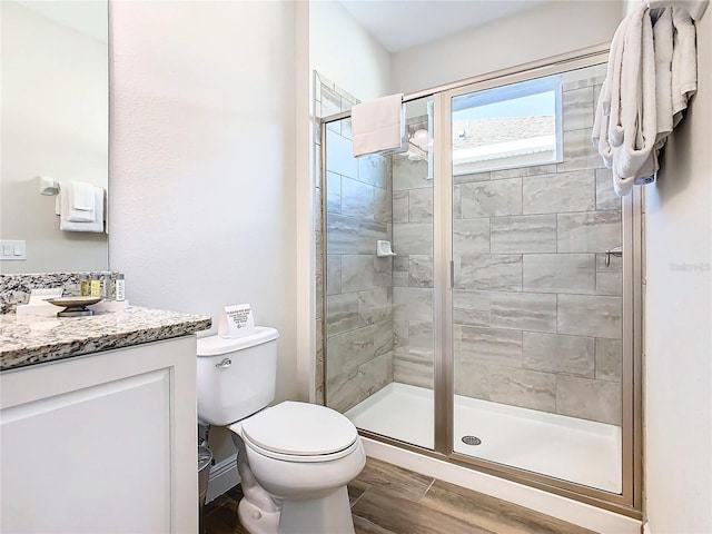 bathroom with an enclosed shower, vanity, and toilet