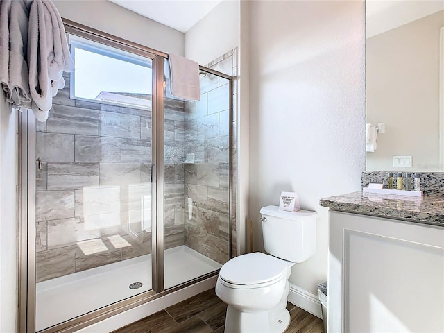 bathroom with walk in shower, vanity, and toilet