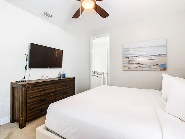 carpeted bedroom with ceiling fan and ensuite bathroom