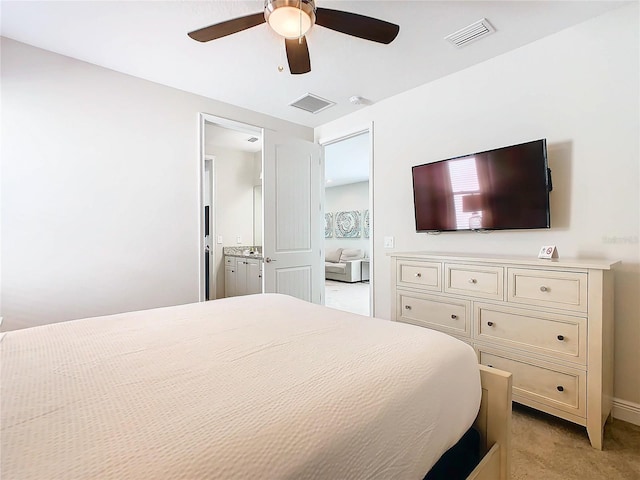 carpeted bedroom with ceiling fan and ensuite bathroom