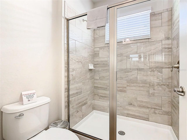 bathroom featuring walk in shower and toilet