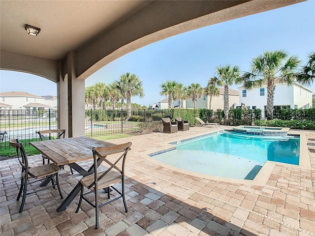 view of swimming pool with a patio and an in ground hot tub