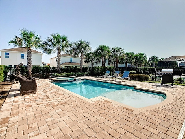 view of swimming pool featuring a patio and an in ground hot tub