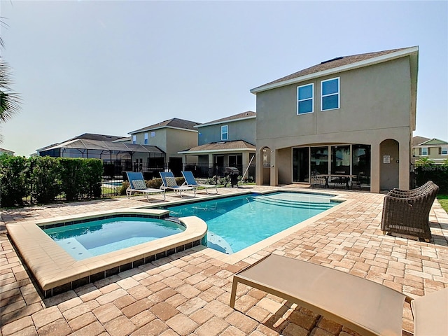 view of swimming pool featuring an in ground hot tub and a patio area