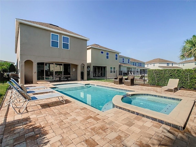 view of swimming pool featuring a patio and an in ground hot tub