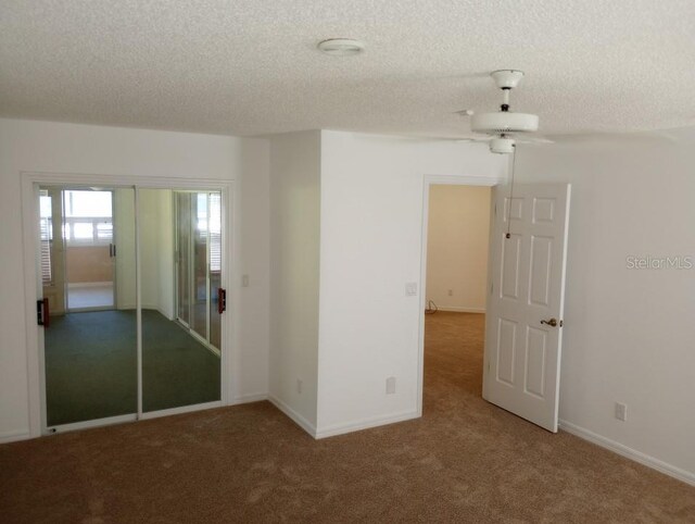 carpeted empty room featuring a textured ceiling