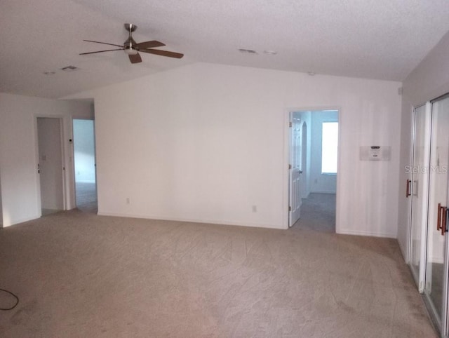 spare room with carpet flooring, ceiling fan, a textured ceiling, and lofted ceiling