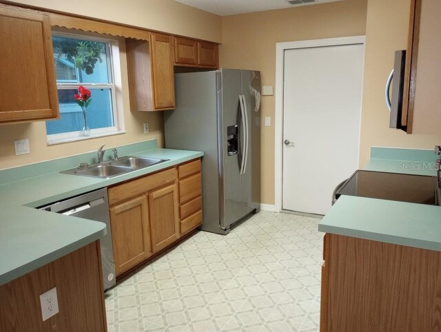 kitchen with sink, light tile floors, and appliances with stainless steel finishes