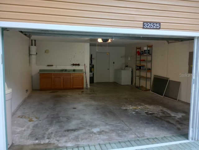 garage with washer and dryer, sink, and a garage door opener