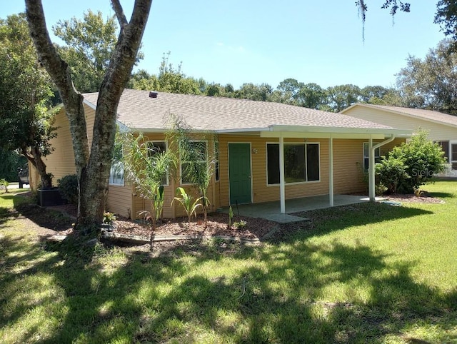 view of front of property featuring a front yard and a shingled roof