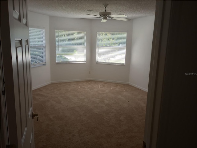 empty room with light carpet, baseboards, a textured ceiling, and ceiling fan