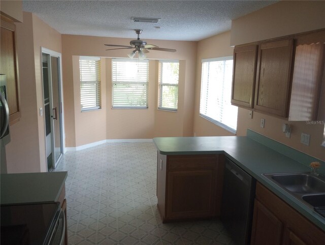 kitchen with kitchen peninsula, ceiling fan, tile floors, dishwashing machine, and a textured ceiling