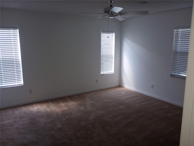 carpeted empty room featuring baseboards and ceiling fan