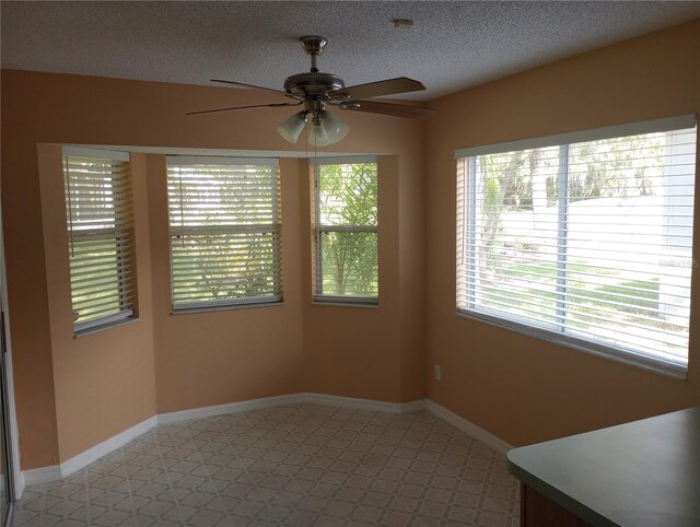 tiled spare room with ceiling fan and a textured ceiling