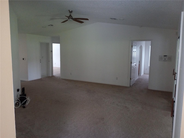 spare room with vaulted ceiling, a ceiling fan, and light carpet