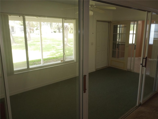 unfurnished sunroom featuring ceiling fan