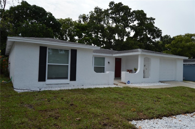 single story home with a garage and a front lawn