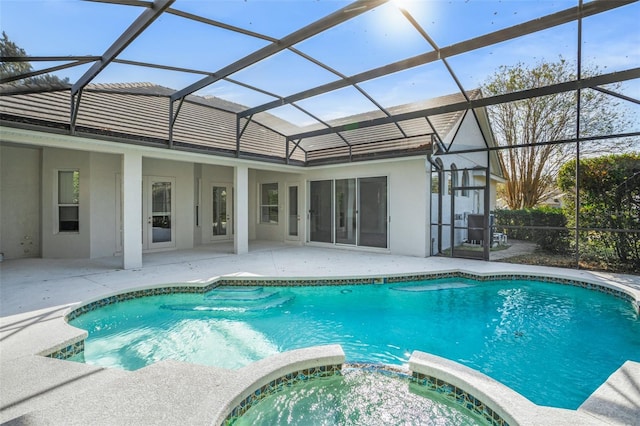 view of swimming pool featuring an in ground hot tub, a patio area, and a lanai