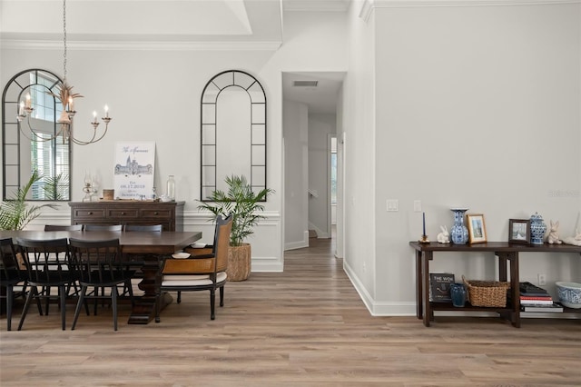 dining room with a chandelier, light hardwood / wood-style flooring, and crown molding