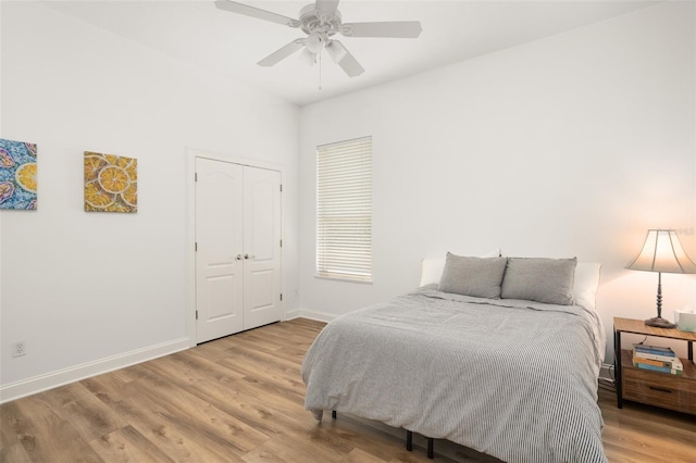 bedroom with ceiling fan, a closet, and light hardwood / wood-style flooring