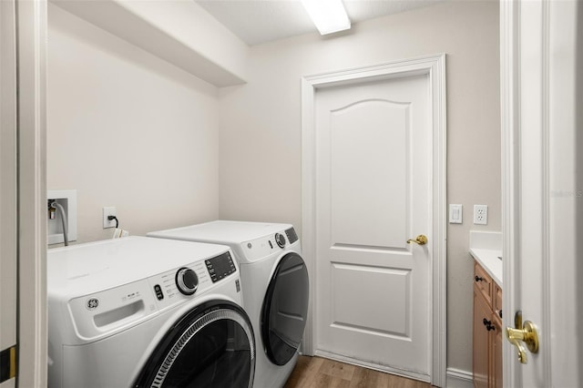 washroom with light hardwood / wood-style floors and washer and clothes dryer