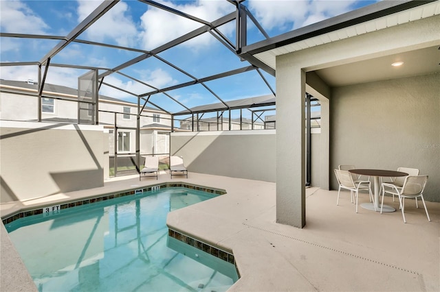 view of pool featuring glass enclosure and a patio