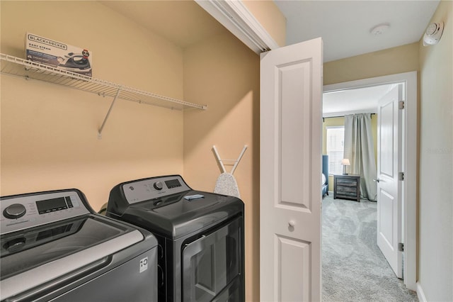 clothes washing area with washer and clothes dryer and light carpet