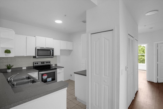 kitchen featuring appliances with stainless steel finishes, backsplash, sink, and white cabinets