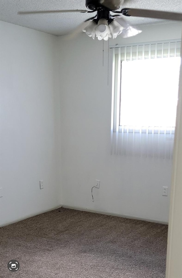 carpeted spare room with ceiling fan and a textured ceiling