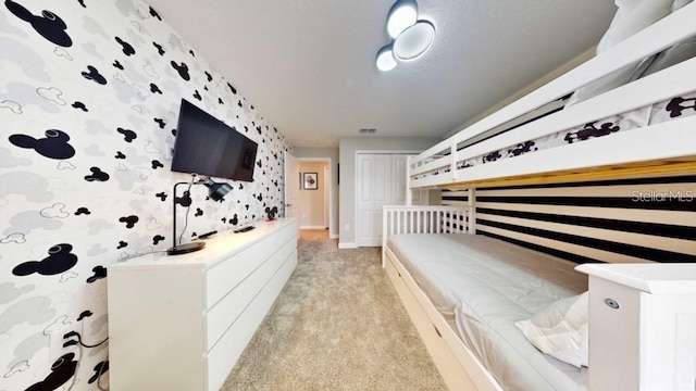 bedroom with light colored carpet and a closet