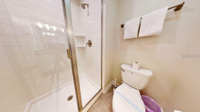 bathroom with a shower with shower door, toilet, and tile flooring