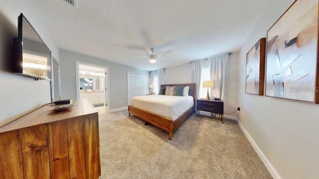 carpeted bedroom featuring ensuite bath, ceiling fan, and a closet