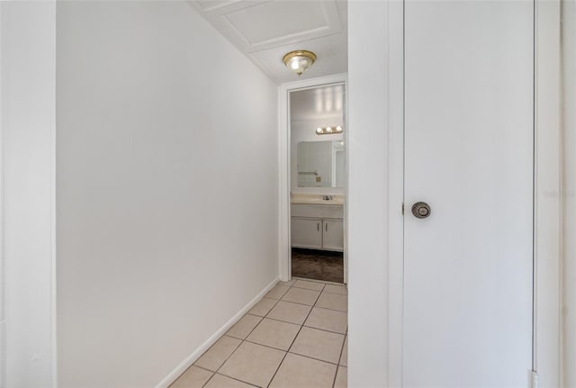 hall featuring sink, light tile patterned floors, and a textured ceiling