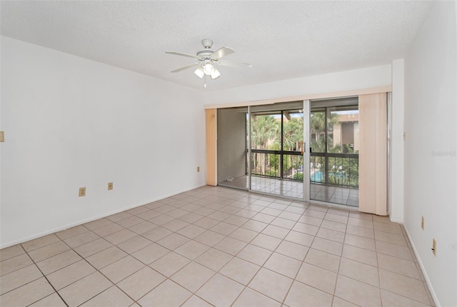 tiled spare room with ceiling fan and a textured ceiling